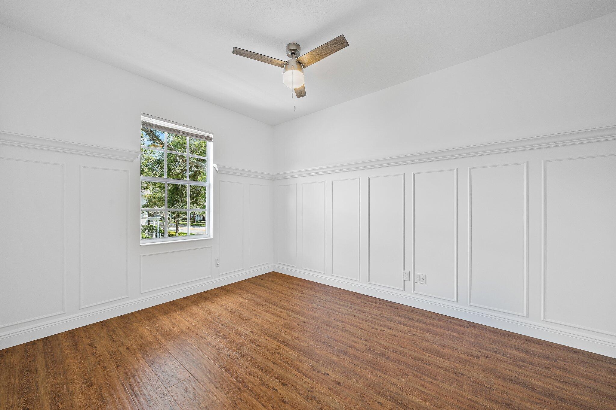 304 Legare Court Jupiter, FL 33458 - Photo 24 of 38 an empty room with wooden floor and windows
