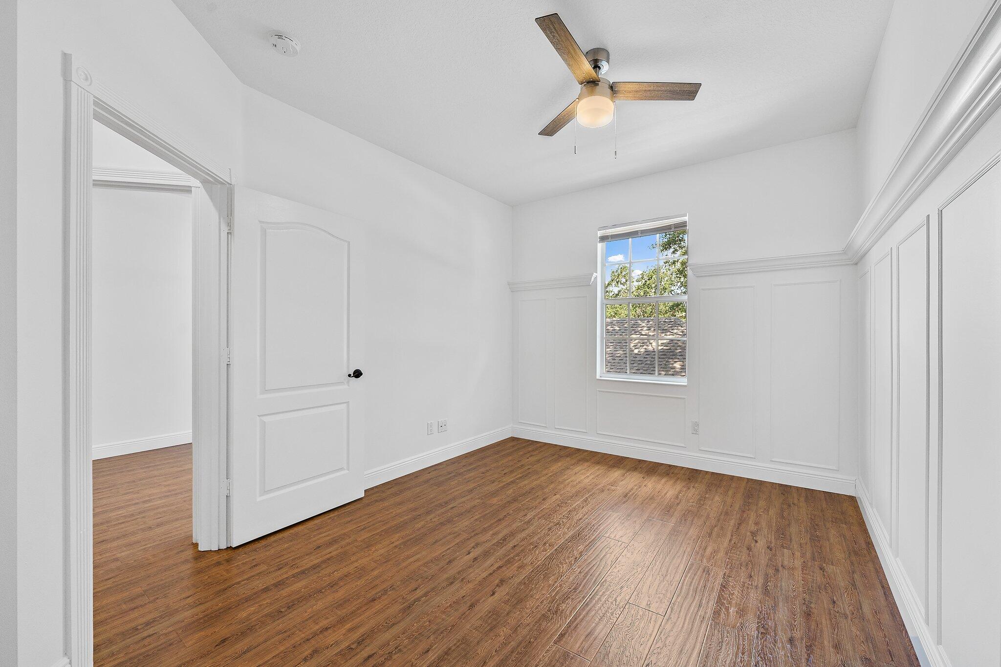 304 Legare Court Jupiter, FL 33458 - Photo 25 of 38 an empty room with wooden floor ceiling fan and windows