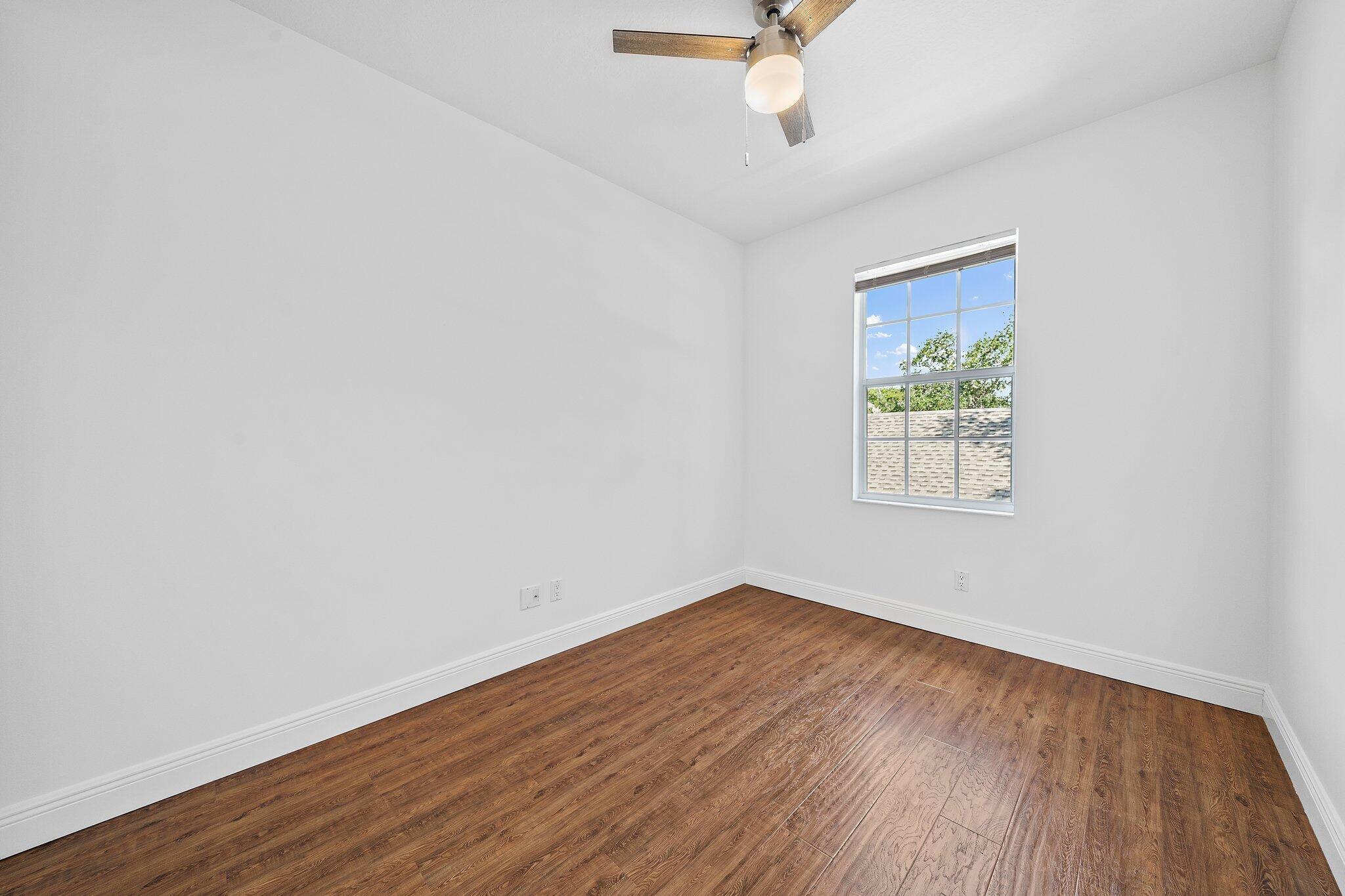 304 Legare Court Jupiter, FL 33458 - Photo 27 of 38 an empty room with a window and wooden floor
