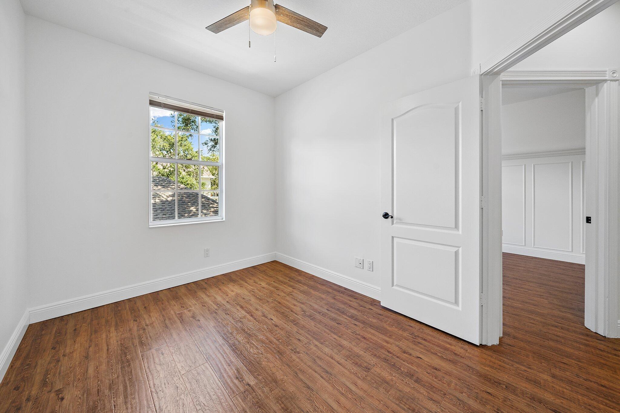 304 Legare Court Jupiter, FL 33458 - Photo 28 of 38 an empty room with wooden floor and windows