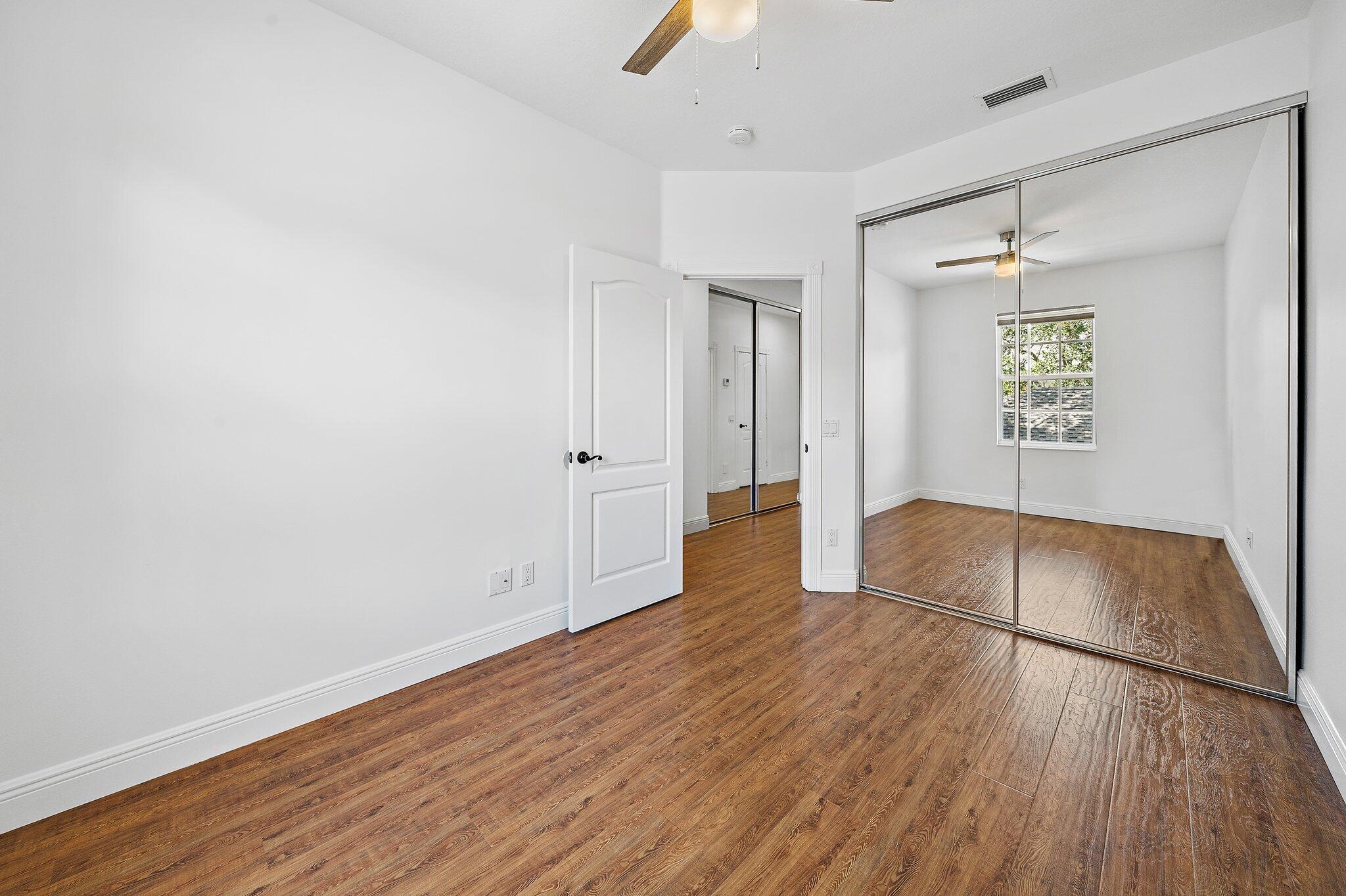 304 Legare Court Jupiter, FL 33458 - Photo 29 of 38 an empty room with wooden floor and windows