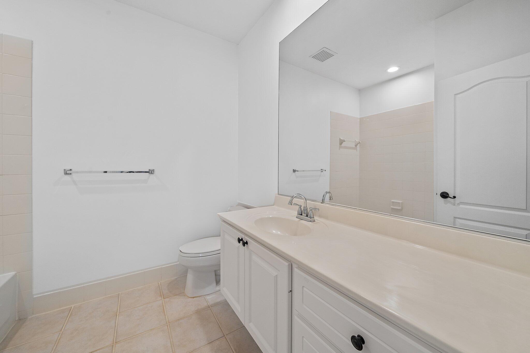 304 Legare Court Jupiter, FL 33458 - Photo 30 of 38 a bathroom with a sink a toilet and a mirror