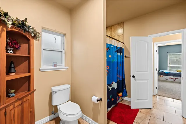 a bedroom with a bed flat screen tv and couches