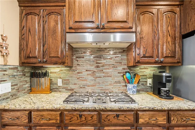 a kitchen with stainless steel appliances granite countertop a sink and cabinets