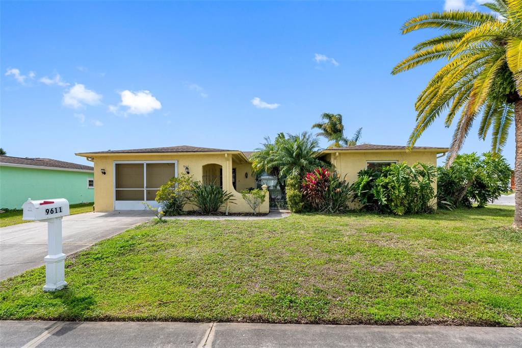 a view of a house with a yard and potted plants