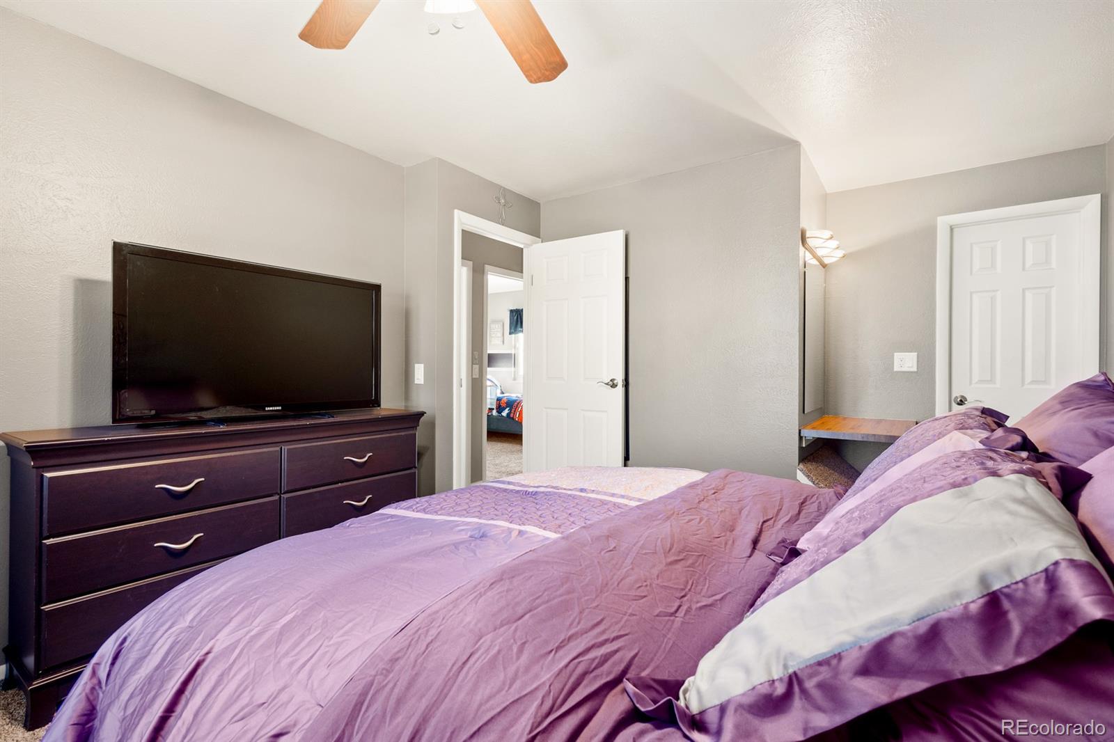 4262 South Quintero Way Aurora, CO 80013 - Photo 14 of 36 a bedroom with a bed and a flat screen tv