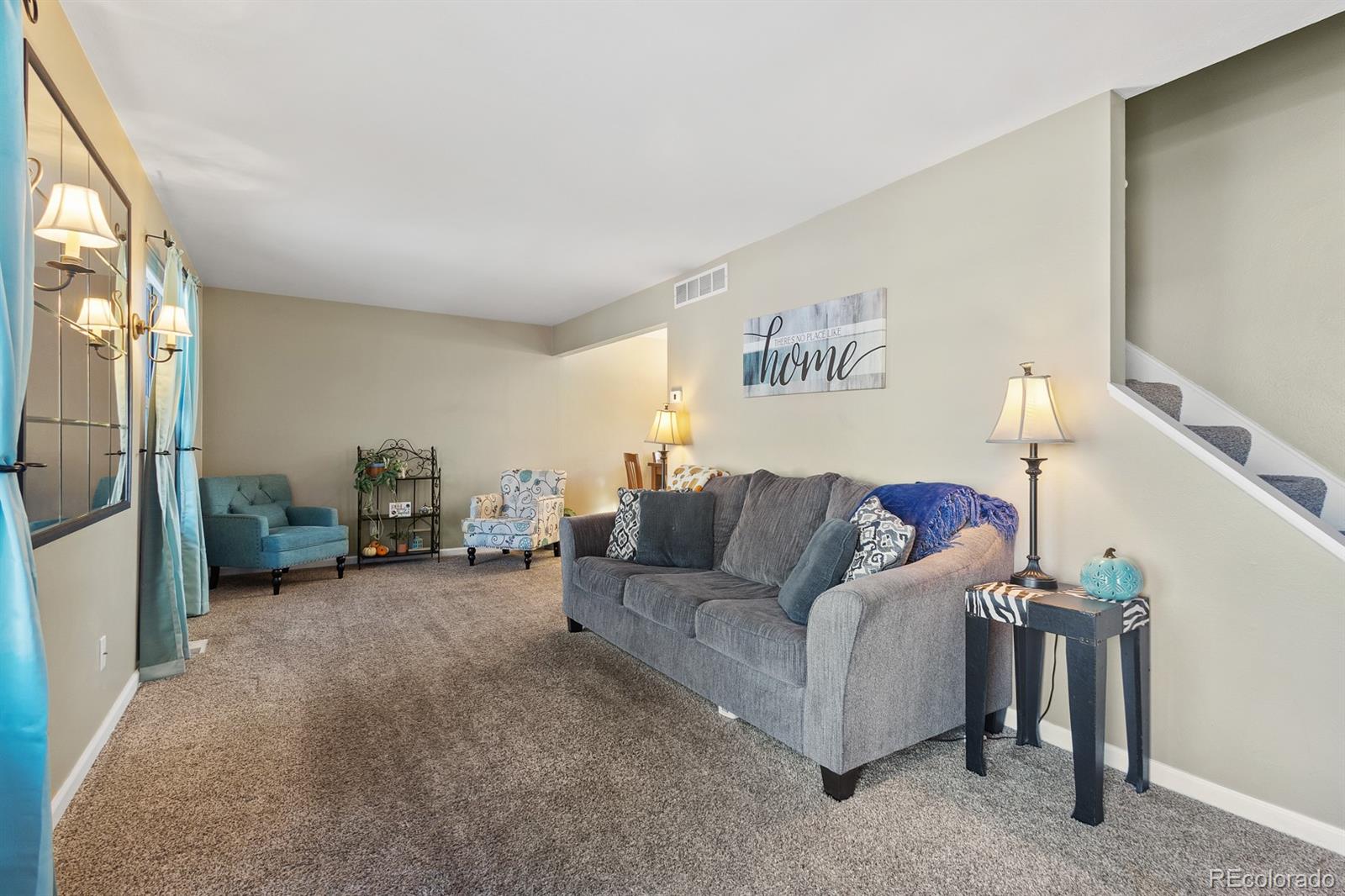 4262 South Quintero Way Aurora, CO 80013 - Photo 3 of 36 a living room with furniture and a lamp
