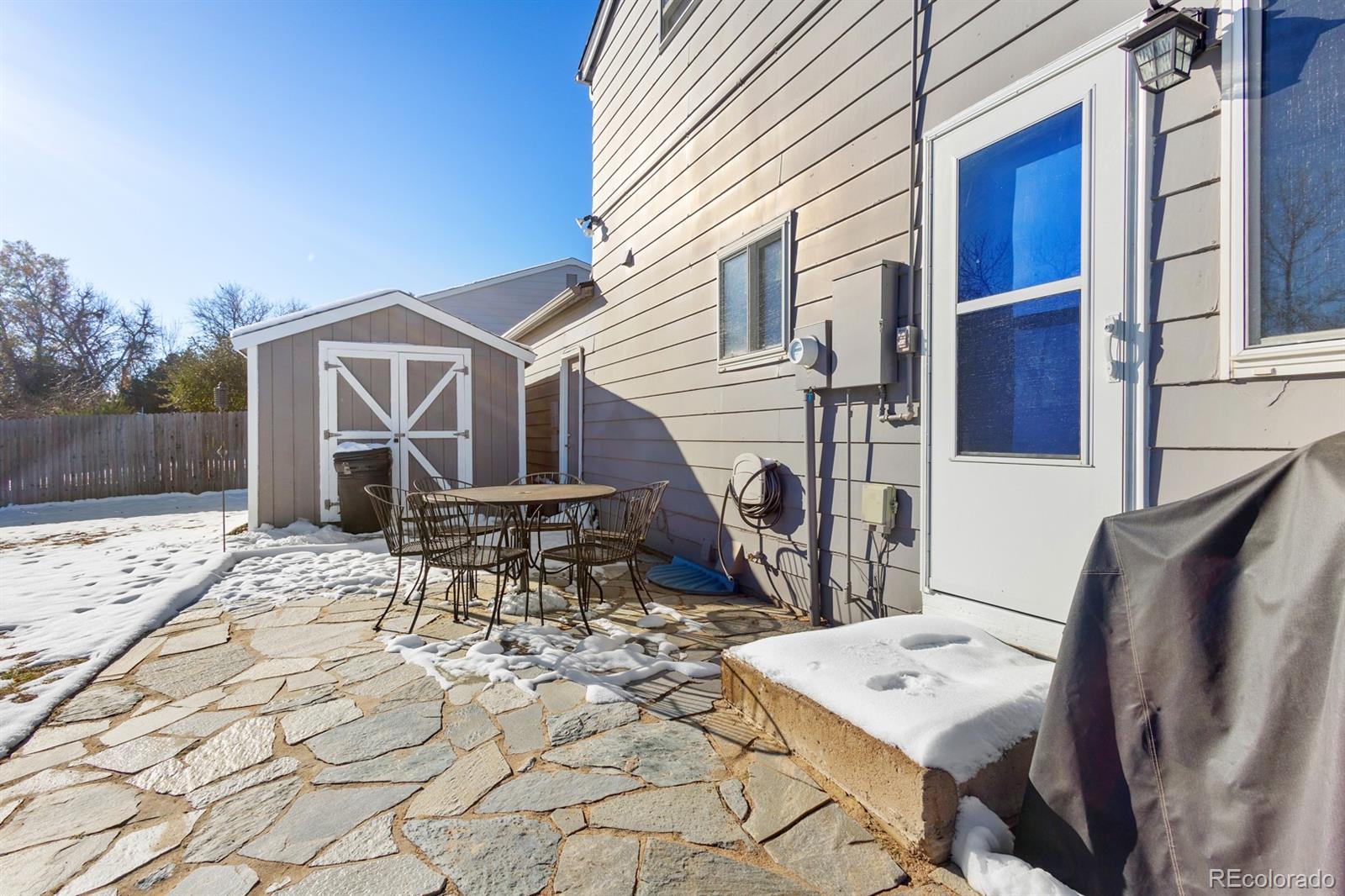 4262 South Quintero Way Aurora, CO 80013 - Photo 32 of 36 a patio with table and chairs with wooden floor and fence