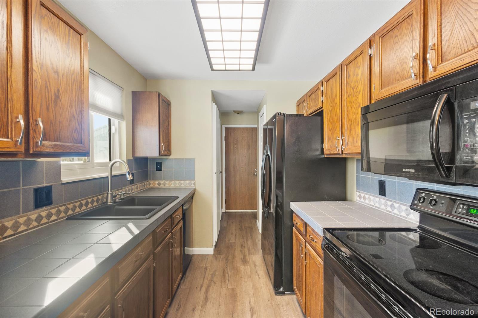 4262 South Quintero Way Aurora, CO 80013 - Photo 7 of 36 a kitchen with stainless steel appliances granite countertop a sink stove and refrigerator