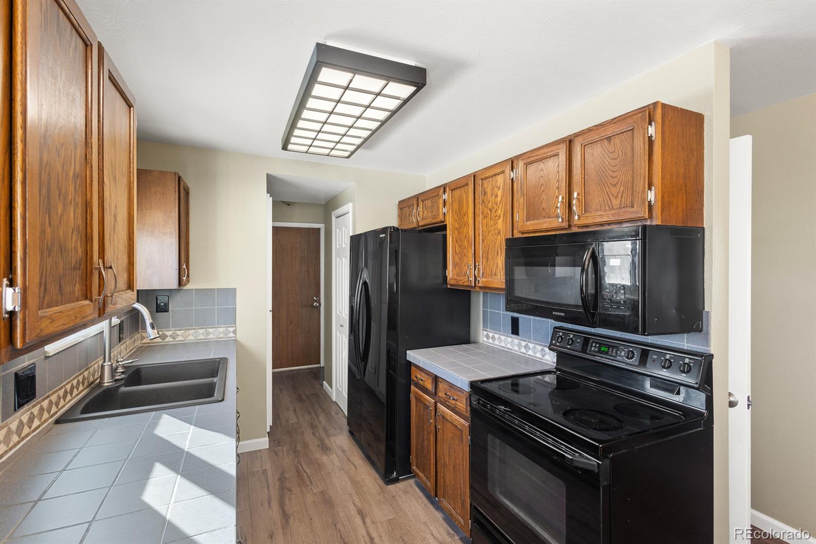 4262 South Quintero Way Aurora, CO 80013 - Photo 8 of 36 a kitchen with stainless steel appliances a stove microwave and sink