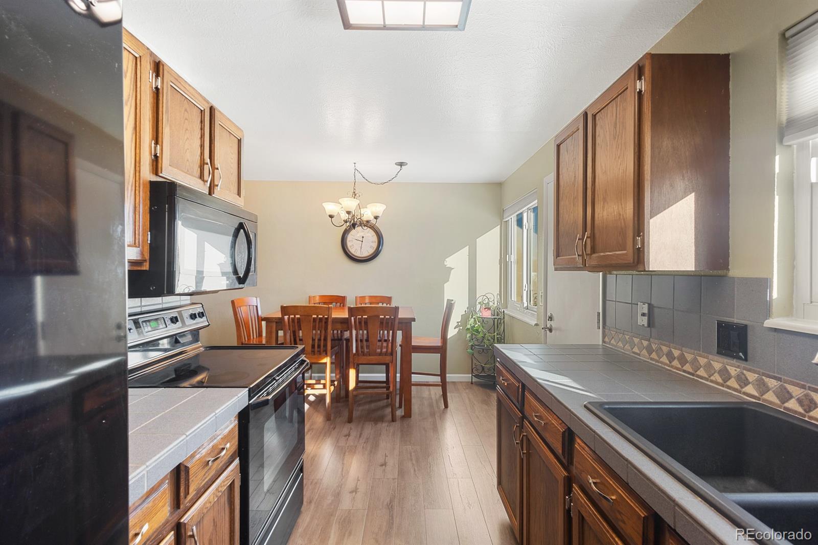 4262 South Quintero Way Aurora, CO 80013 - Photo 9 of 36 a kitchen with a sink a stove and cabinets