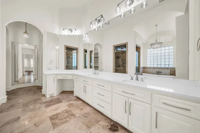 a spacious en suite bathroom with double sink and a mirror