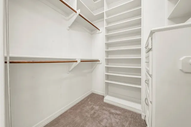 a view of walk in closet with empty racks