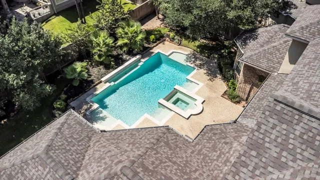 an aerial view of a house with a yard and lake view