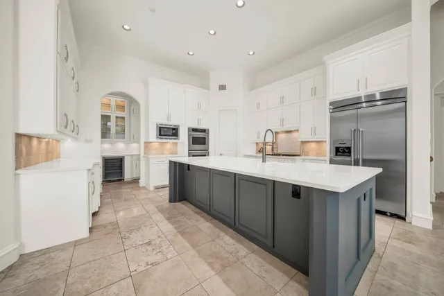 a kitchen with stainless steel appliances kitchen island granite countertop a refrigerator and a stove top oven