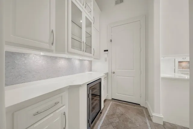 a kitchen with white cabinets and a fireplace