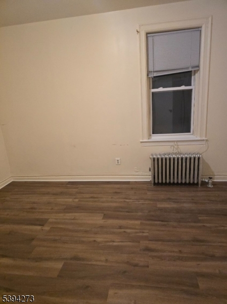 135 40th Street, Unit 104 Union City, NJ 07087 - Photo 2 of 4 a view of an empty room with wooden floor and a window