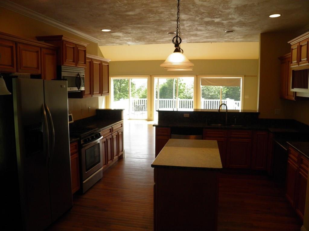 115 Fisherdick Road Ware, MA 01082 - Photo 28 of 30 a kitchen with a stove a refrigerator and a dining table