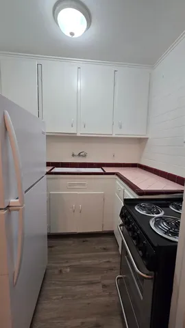 a view of a kitchen with wooden floor and stainless steel appliances