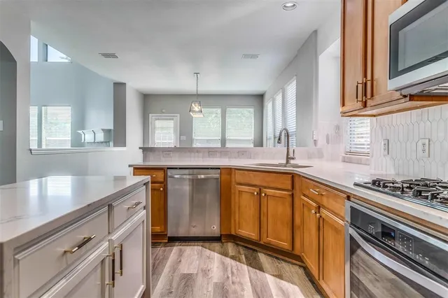 a kitchen with stainless steel appliances a sink stove and cabinets
