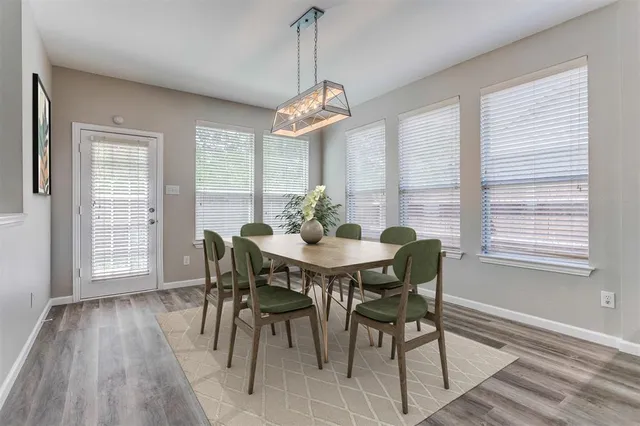 a dining room with furniture a chandelier and wooden floor