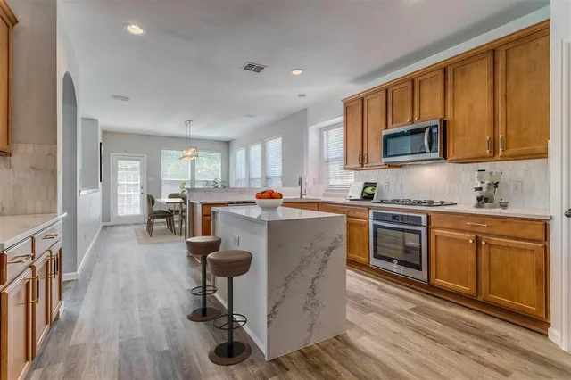 a kitchen with counter top space a sink appliances and cabinets