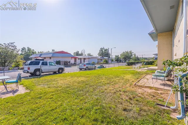 a view of a swimming pool with lawn chairs and a yard
