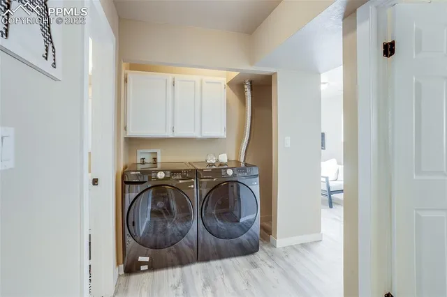 a utility room with wooden floor washer and dryer