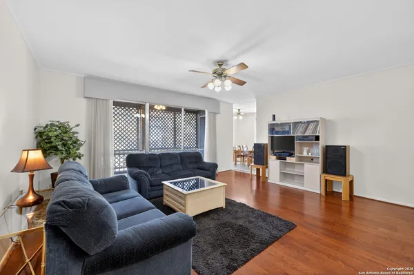 a living room with furniture and a wooden floor
