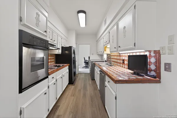 a kitchen with stainless steel appliances kitchen island granite countertop a stove a sink and a refrigerator