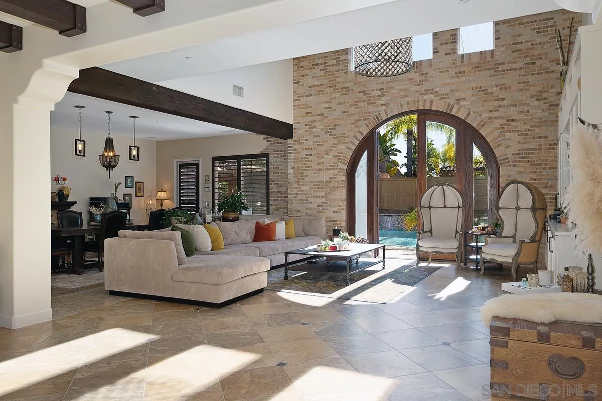 14779 Rio Rancho San Diego, CA 92127 - Photo 6 of 35 a living room with couches a fireplace and a large mirror with wooden floor