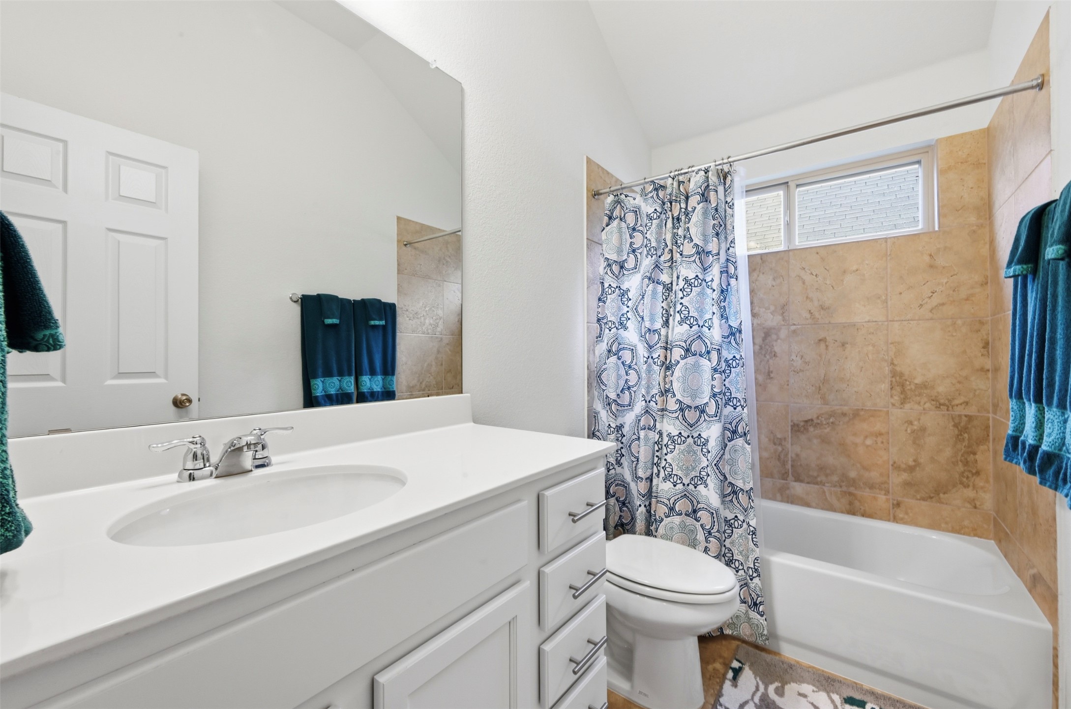 13116 Alans Way Manchaca, TX 78652 - Photo 18 of 25 Bathroom featuring a white vanity with an integrated sink, a large wall-mounted mirror, and a full-size bathtub with a tiled surround
