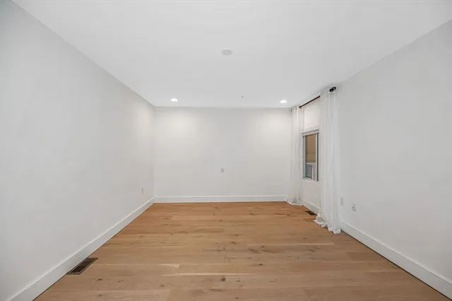 a view of a big room with wooden floor and windows