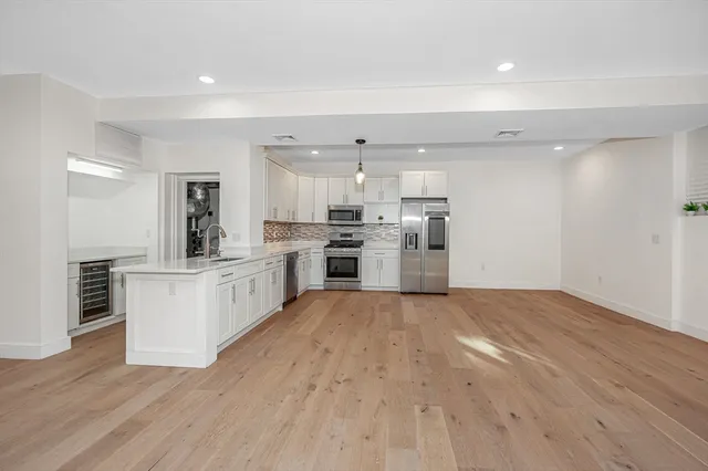 a large kitchen with a center island and stainless steel appliances