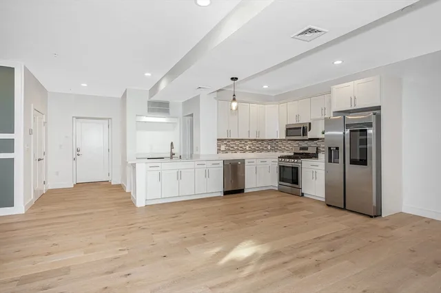 a kitchen with white cabinets and stainless steel appliances