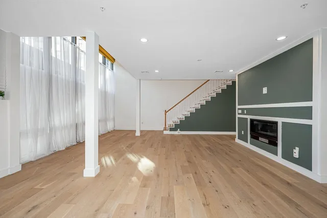 a view of empty room with wooden floor and fireplace