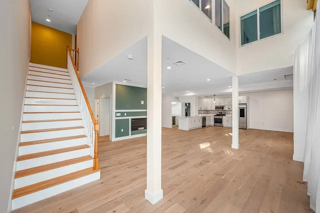 a view of a living room with wooden floor and staircase