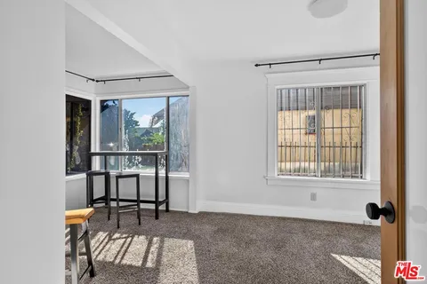 a view of a room that has a window and wooden floor