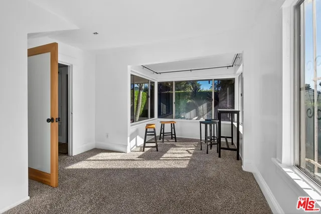 a living room with a large window and a dining table