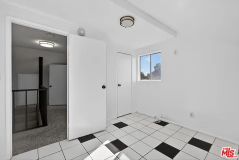a kitchen with a checkered floor and steel appliances