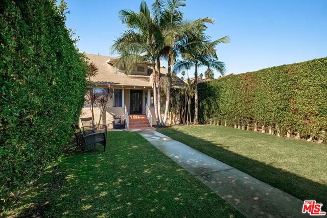 a view of a house with backyard and a tree