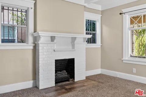 a living room with a fireplace and windows