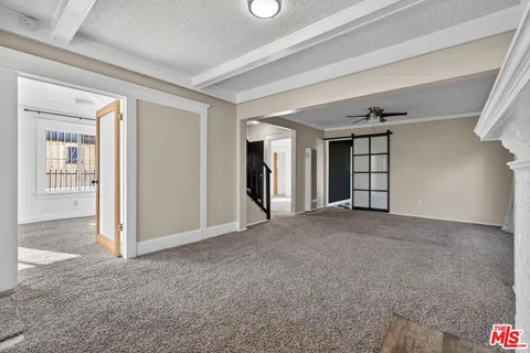 a view of a big room with windows and chandelier