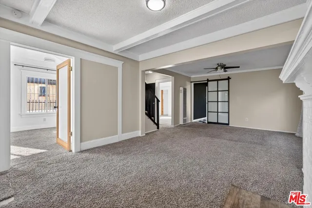 a view of a big room with windows and chandelier