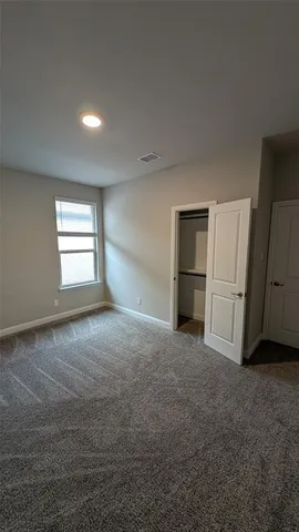 a bedroom with bed and a large window