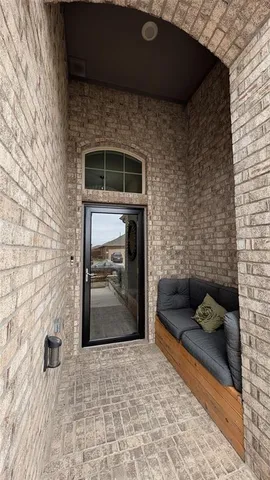 a view of an empty room with chandelier fan and wooden floor