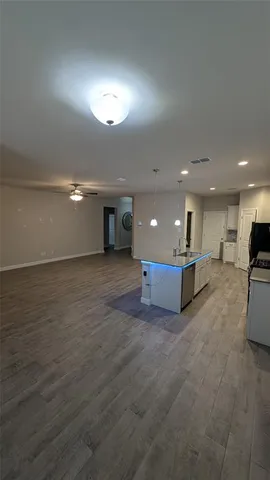 a large white kitchen with a refrigerator a stove top oven a sink and cabinets