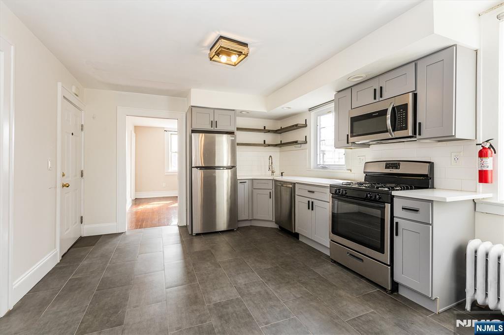 43 Pleasant Way Montclair, NJ 07042 - Photo 6 of 28 a kitchen with stainless steel appliances a refrigerator stove and microwave