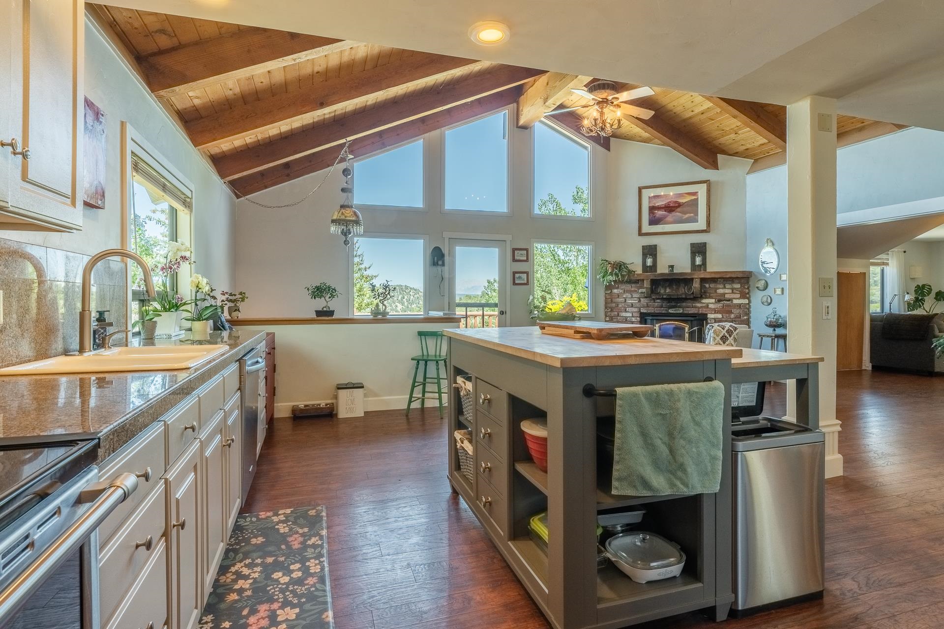 537 Aspen Spring Ranch Road Mammoth Lakes, CA 93546 - Photo 6 of 40 Open-concept kitchen featuring an expansive window wall, vaulted wood-beam ceiling, a large central island with wood countertop, granite-finish countertops, and wood-finish flooring