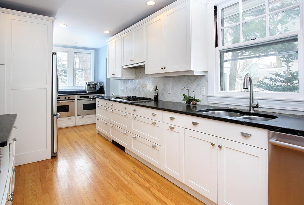 60 Evans Road Brookline, MA 02445 - Photo 7 of 15 a kitchen with stainless steel appliances granite countertop a stove a sink and white cabinets